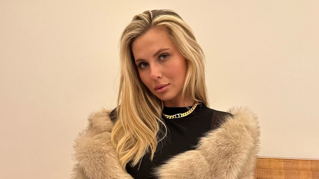 Madison Bass flawlessly channels high-end winter glamour by layering a luxurious faux fur coat over a classic black top, perfectly accessorized with a statement gold chain necklace.