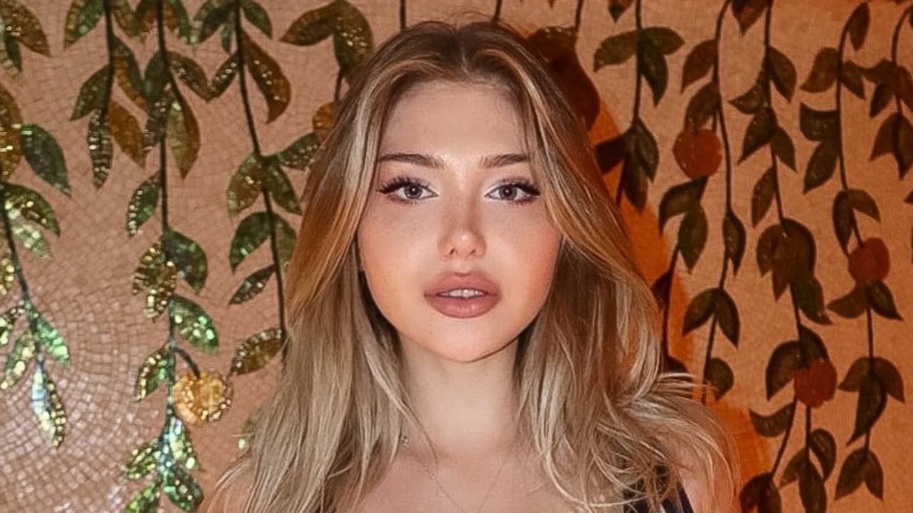 Blackwidof effortlessly merges casual chic with an artistic touch, pairing voluminous honey-highlighted hair and understated makeup against a rich mosaic backdrop.