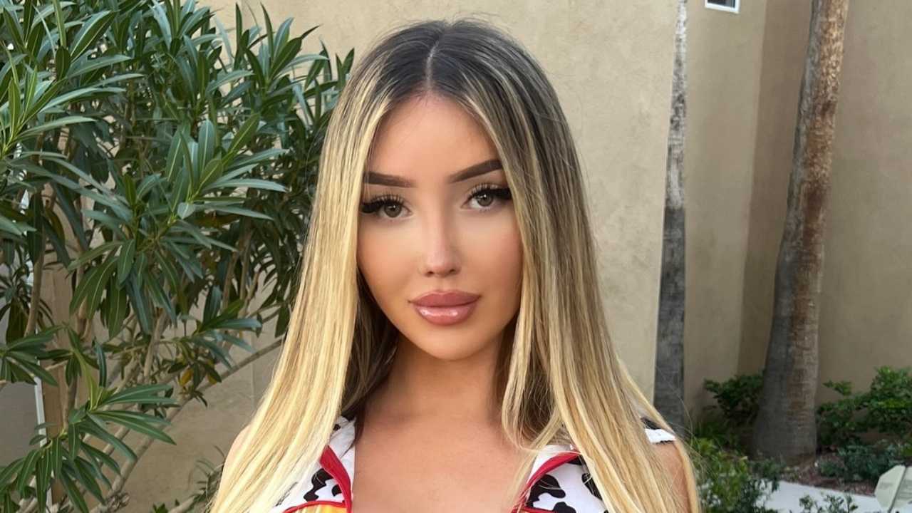 Carli Nicki highlights a flawless daytime glam aesthetic with sleek two-tone blonde hair and polished, sun-kissed makeup that effortlessly elevates her casual streetwear style.