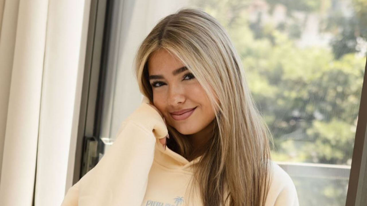 Embreigh Courtlyn embraces a comfortable aesthetic with this soft, cream-colored oversized hoodie, demonstrating effortless casual style.