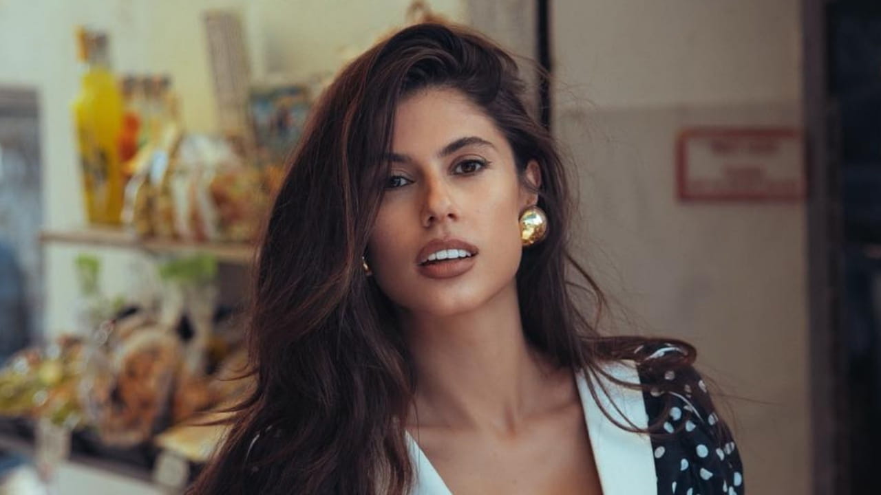 Ines Trocchia channels timeless Mediterranean glamour with bold chunky gold statement earrings and a vintage-inspired polka-dot ensemble.