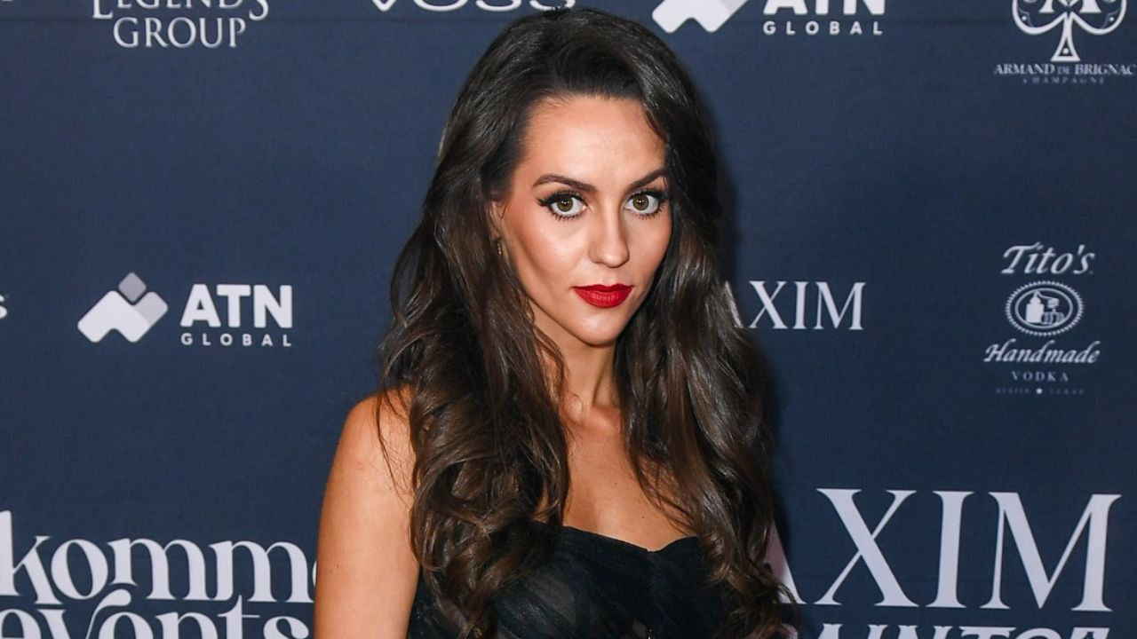 Jordon Hudson embodies classic elegance on the red carpet with a stunning black outfit and a bold red lip.