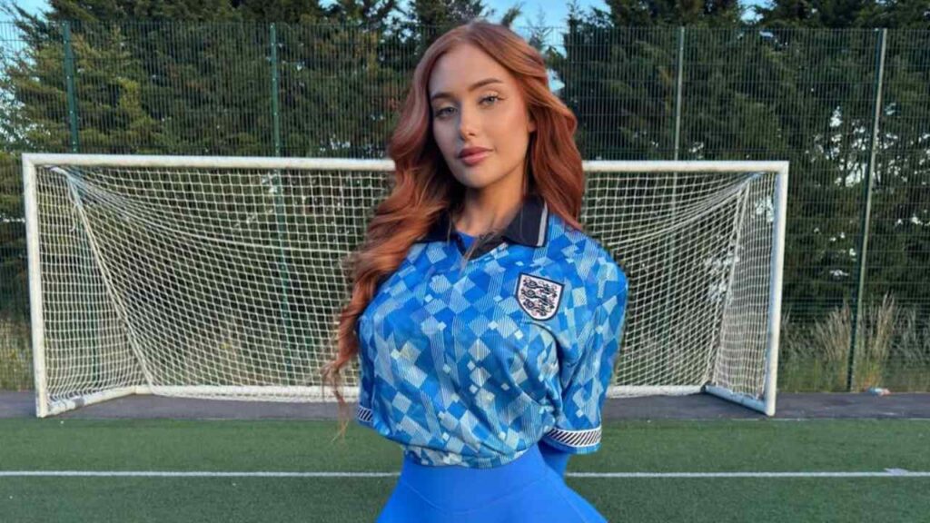 Channeling the popular blokecore trend, Rosie Harper styles a retro-inspired geometric blue soccer jersey with matching athletic leggings for a fresh, sporty aesthetic.