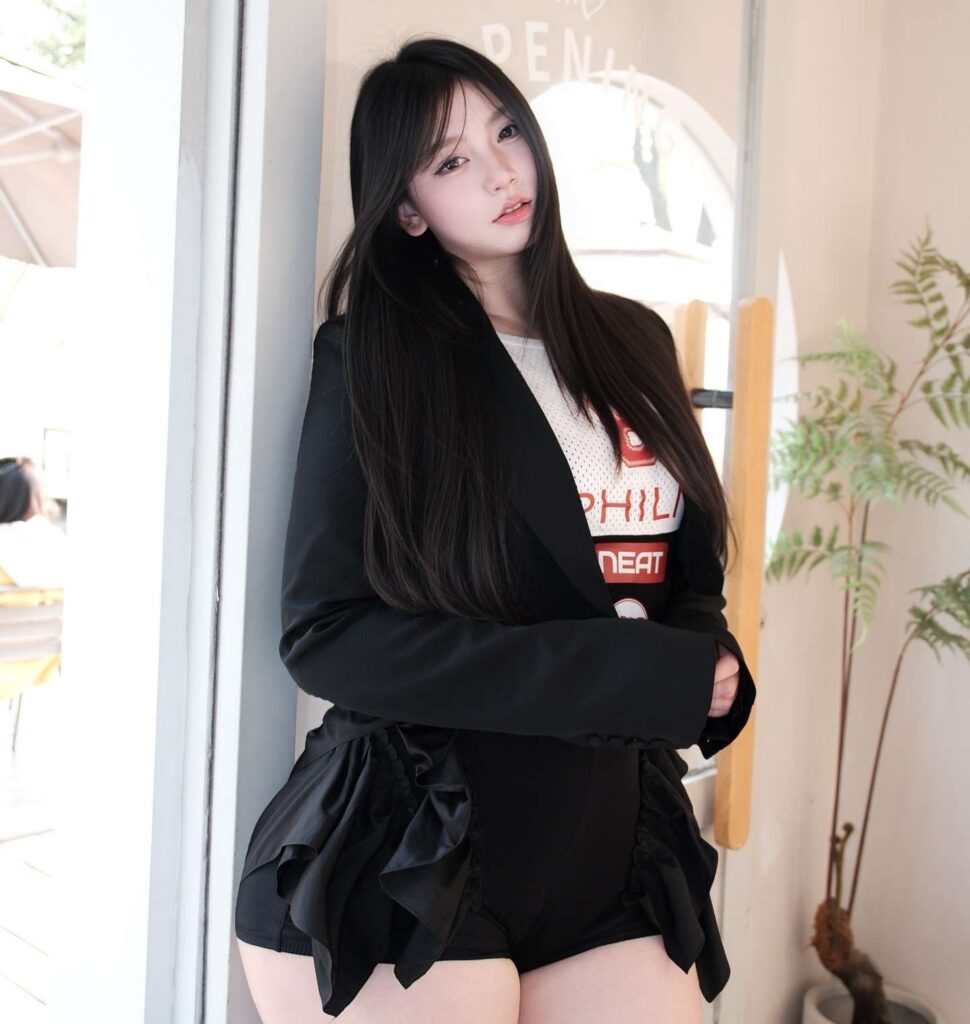 Sika Cheng masters contemporary street-smart tailoring by pairing a sharp black blazer with a sporty graphic tee and sculptural ruffle-trimmed shorts.