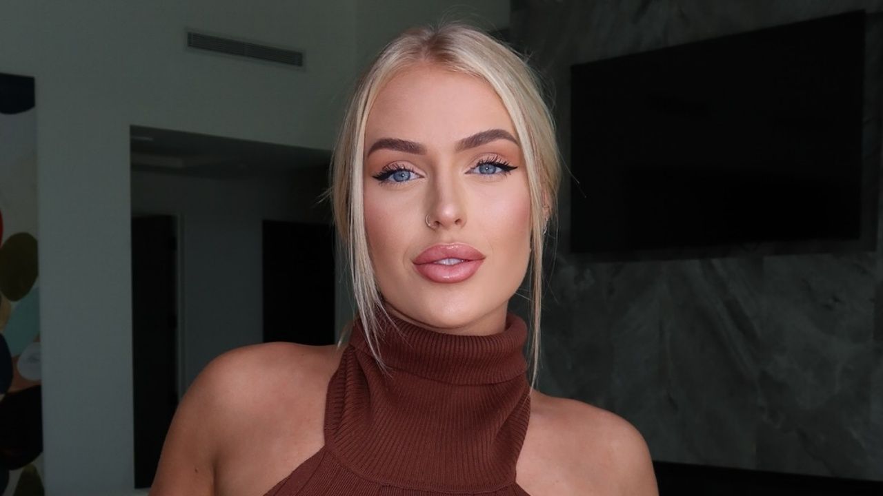 Tiauna Riley radiates effortless glam in a rich chocolate brown ribbed knit halter top paired with a sleek updo and glowing, sun-kissed makeup.