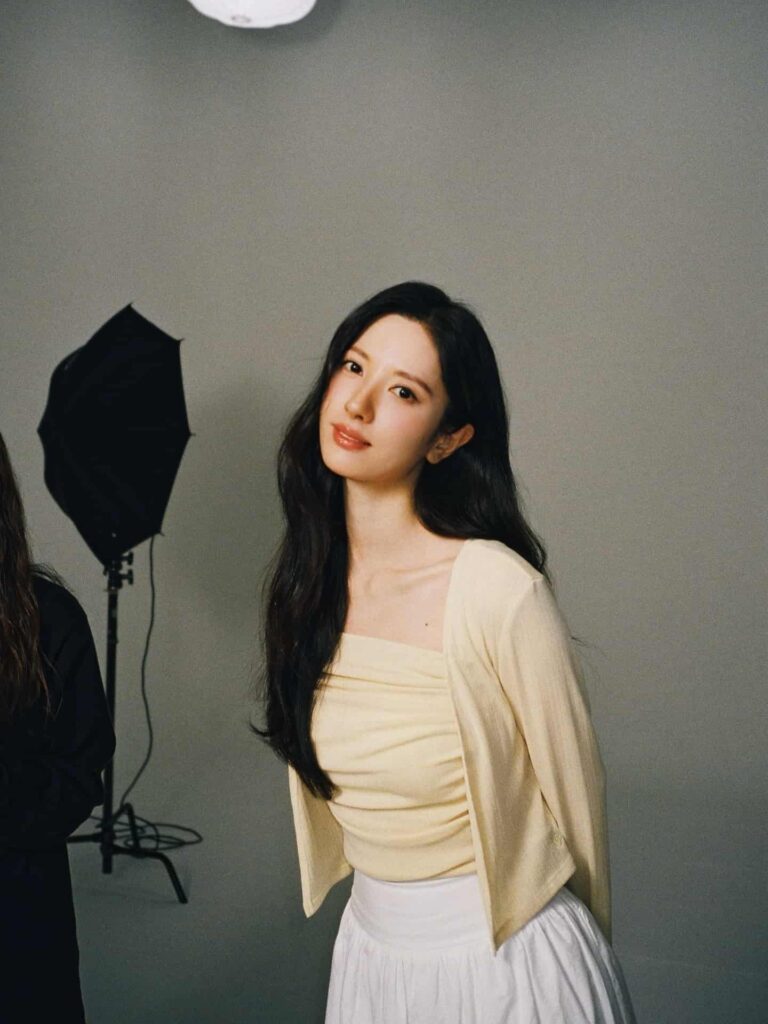 Mastering the soft luxury aesthetic, Bona pairs a pastel butter-yellow ruched knit top with a matching cardigan and an airy white high-waisted skirt for a fresh, refined feminine silhouette.