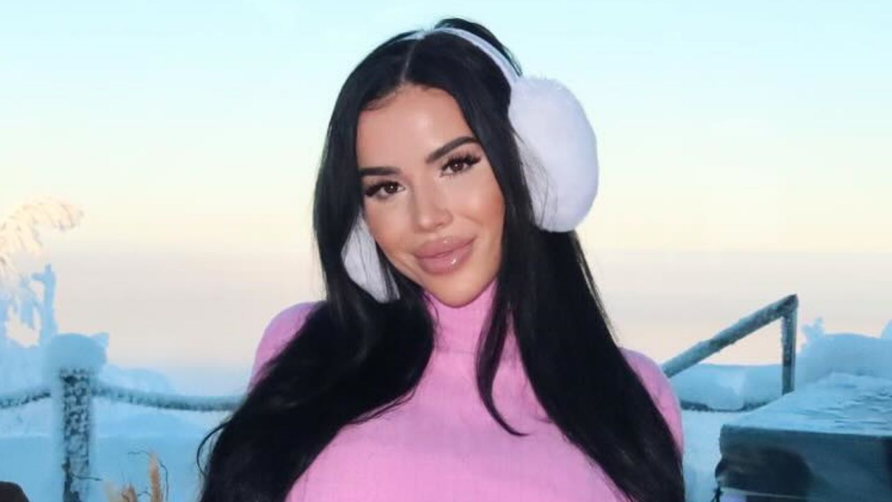 Desiree Dee embraces a chic après-ski aesthetic, effortlessly styling a pastel pink turtleneck knit with plush white earmuffs for the ultimate winter-glam statement.