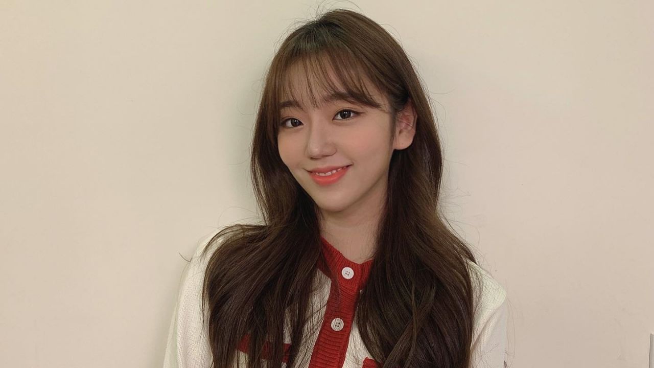 Jeon Hye Won embodies cozy preppy elegance in an off-white textured cardigan accented by vibrant red trim, perfectly blending classic knitwear with a fresh, everyday chic aesthetic.