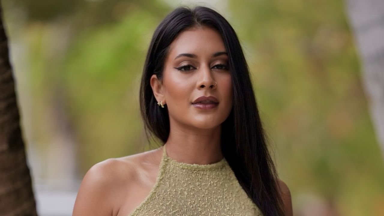 Jisel Lynn embodies effortless warm-weather glamour in a textured olive-green knit halter top, beautifully complemented by radiant bronzed makeup, a defined winged eye, and sleek brunette locks.