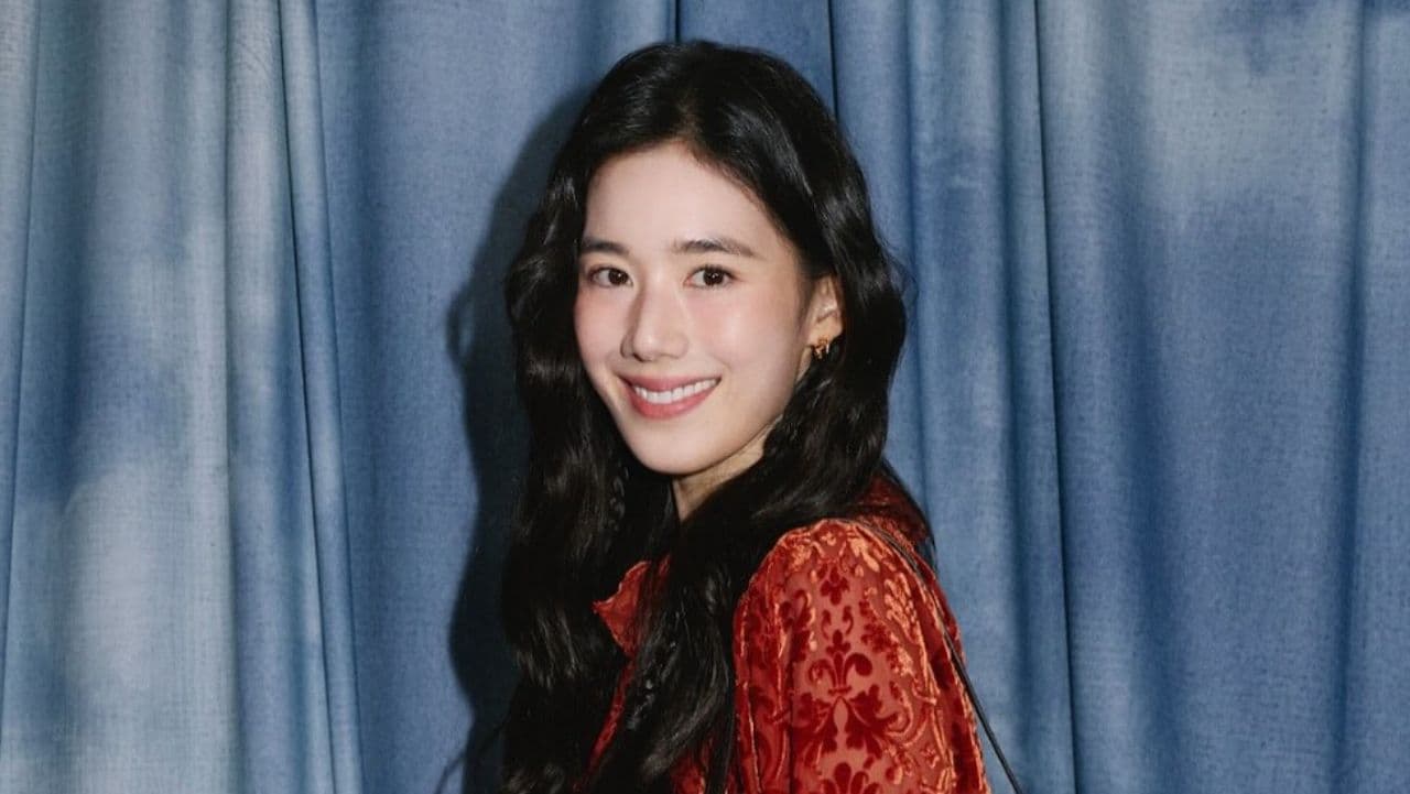 Jung Eun Chae radiates vintage romantic charm in a rich rust-toned textured jacquard blouse with delicate ruffled detailing, effortlessly complemented by soft, cascading waves.