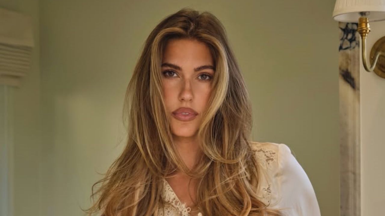 Kara Del Toro radiates effortless elegance in a delicate cream lace blouse, perfectly paired with a voluminous blowout for a soft, romantic indoor portrait.