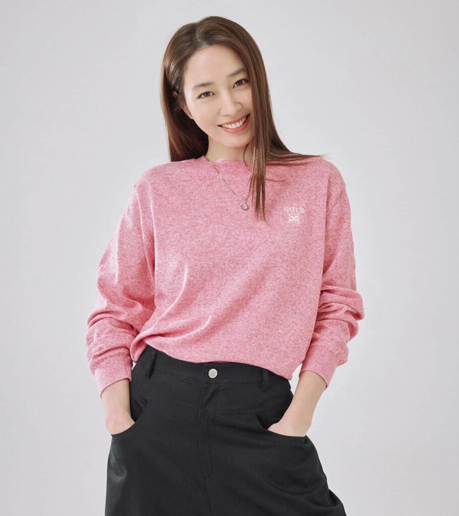 Showcasing a vibrant approach to premium casual style, Lee Min Jung pairs a luxuriously soft pink sweater with classic black pants for the ultimate trendy and versatile wardrobe inspiration.