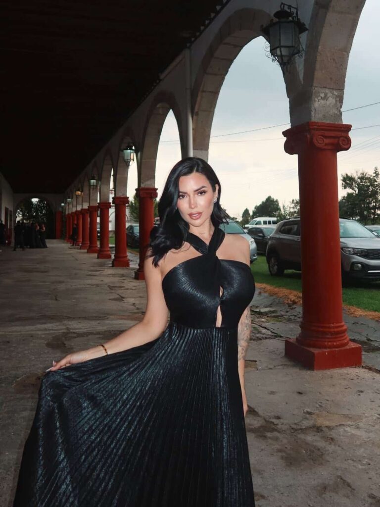 Luchi Del Mar epitomizes evening glamour in a flowing black pleated halter gown that balances a sophisticated keyhole cutout with textured, red-carpet-ready elegance.