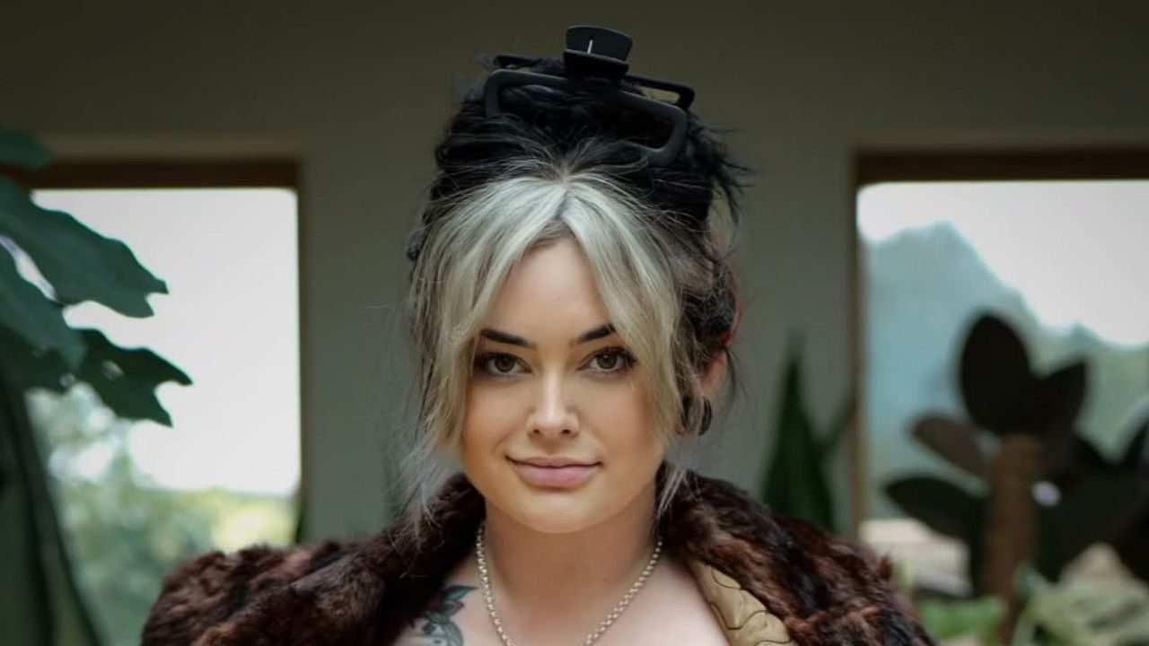 Mamaplugs rocks a bold streetwear look featuring a cozy faux-fur coat paired with trendy face-framing hair highlights and an effortless claw clip updo.