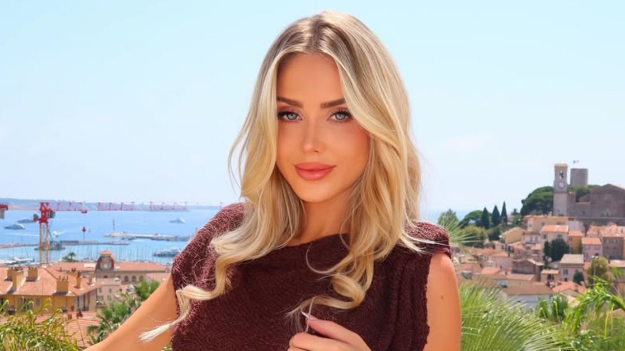 Marli Buccola embraces effortless coastal elegance by pairing a rich chocolate-brown textured knit top with soft, sun-kissed waves against a picturesque Mediterranean backdrop.