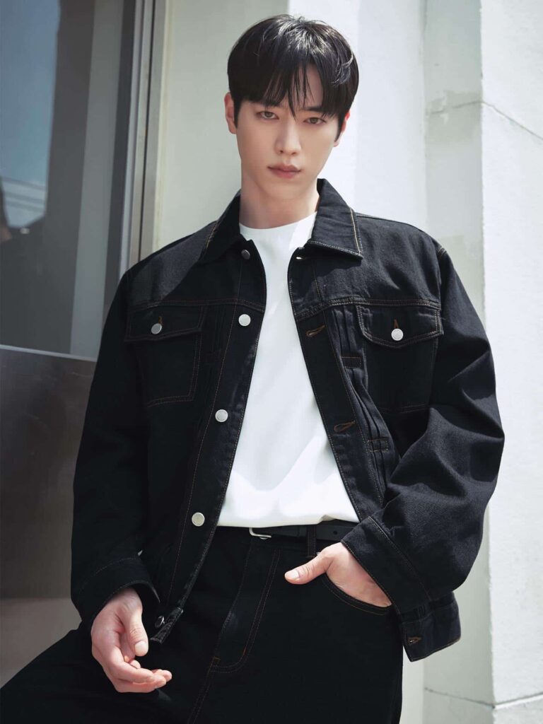 Mastering modern smart-casual layering, Seo Kang Joon pairs a structured dark denim jacket with a crisp white crew-neck tee and tailored black trousers for a timeless, high-contrast urban aesthetic.
