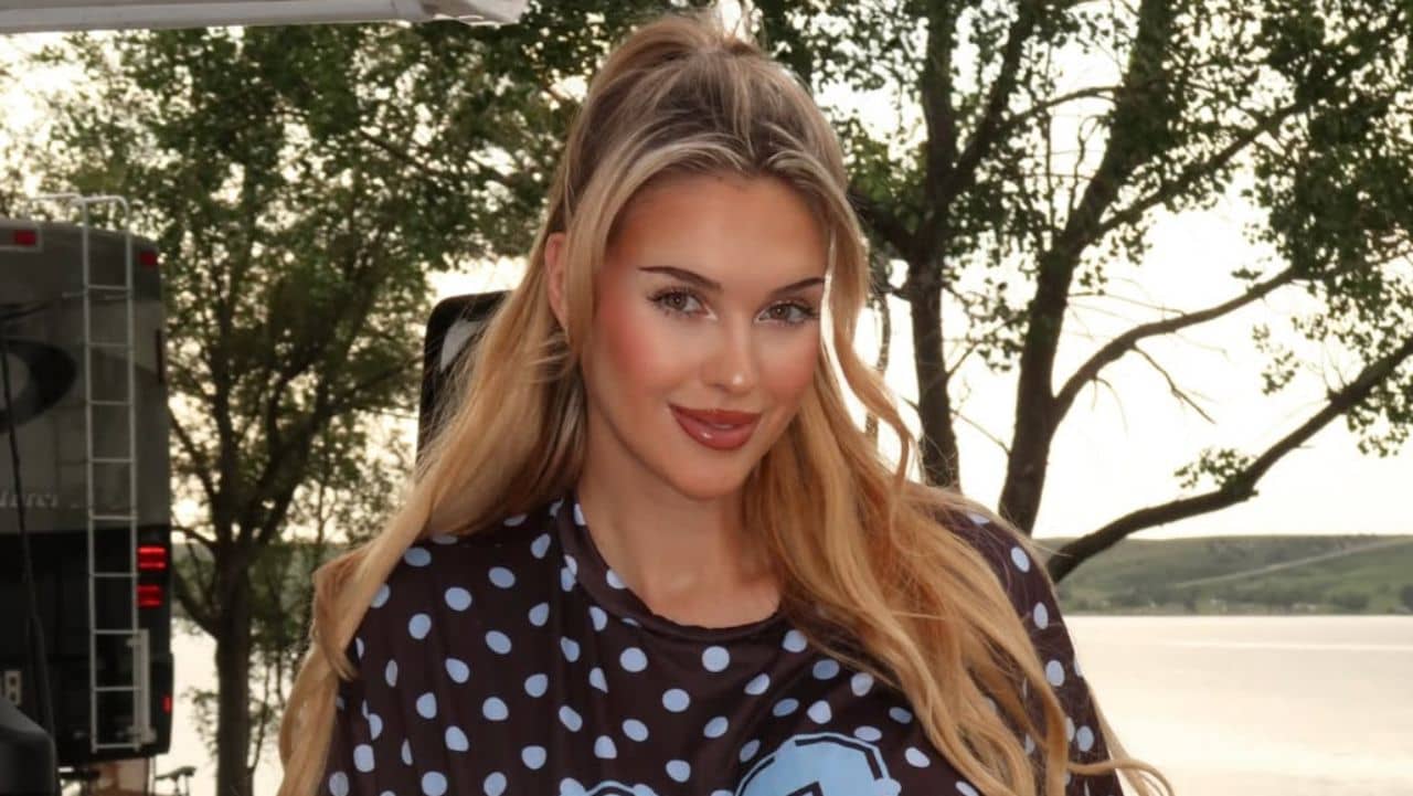 Veronika Rajek effortlessly pulls off a casual, sporty aesthetic, pairing a playful polka-dot athletic tee with a perfectly styled half-up ponytail for a relaxed outdoor look.